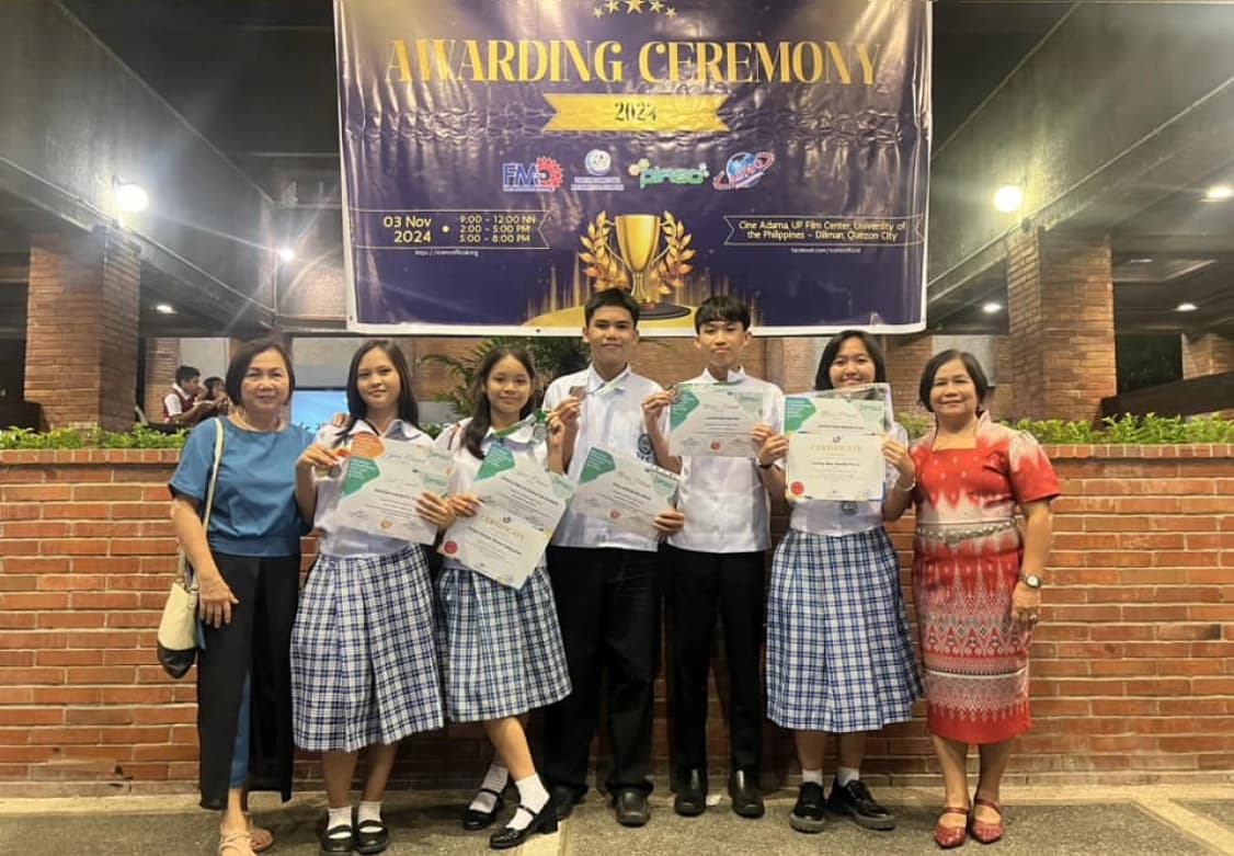 Some students of NNHS at an awarding ceremony showing their certificates and medals